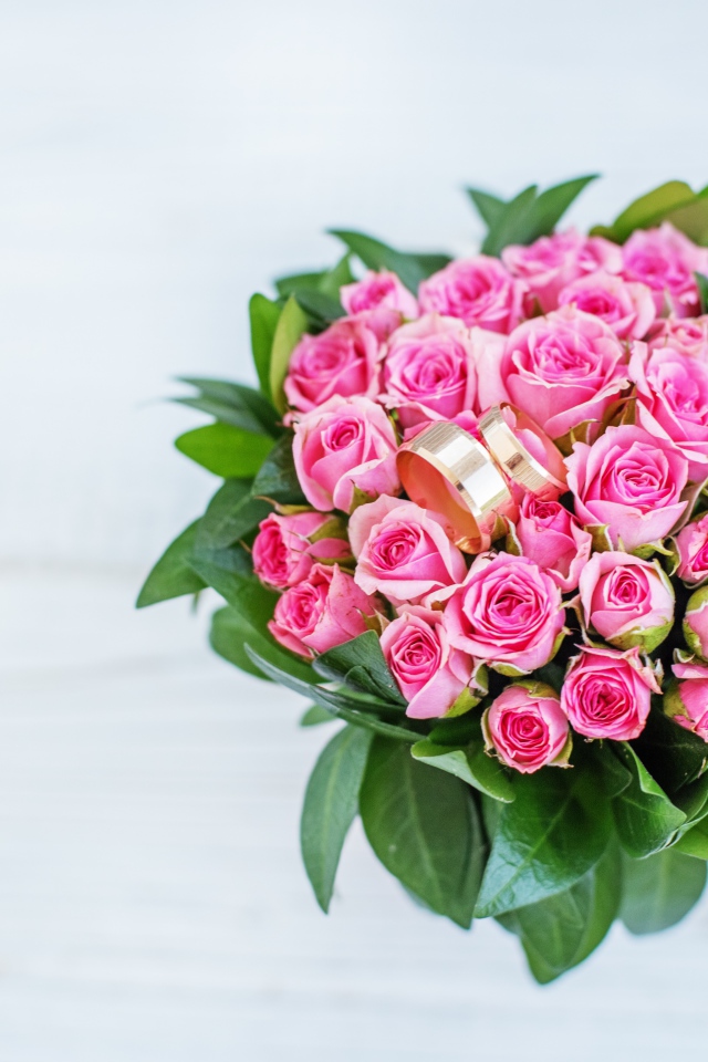 Большой букет розовых роз с золотыми обручальными кольцами