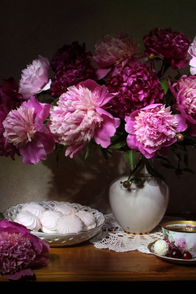 Красивый букет пионов в вазе на столе с зефиром