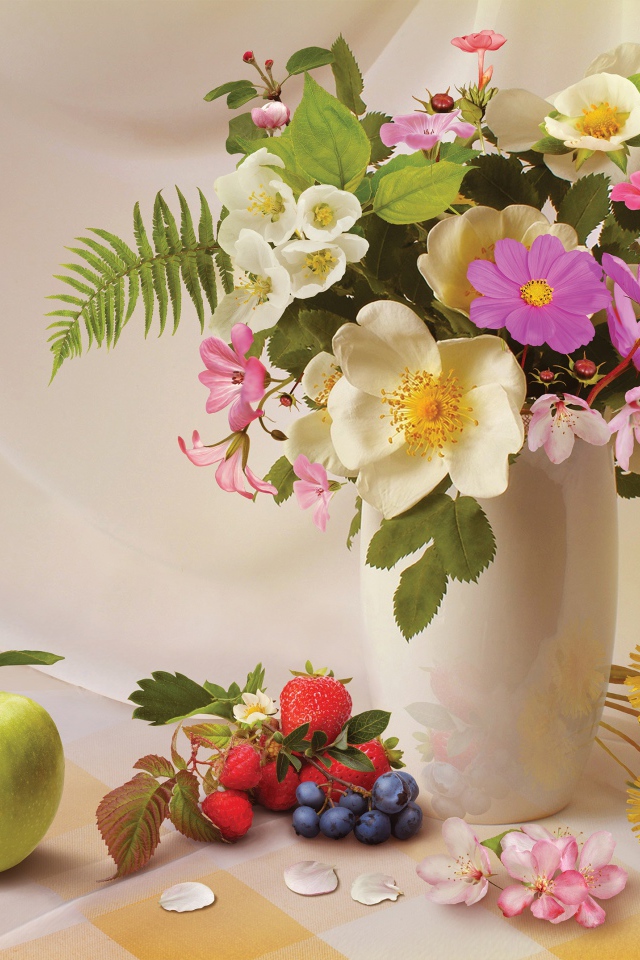 Букет в вазе на столе с фруктами и ягодами