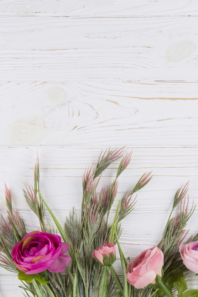 Букет разноцветных лютиков на белом столе