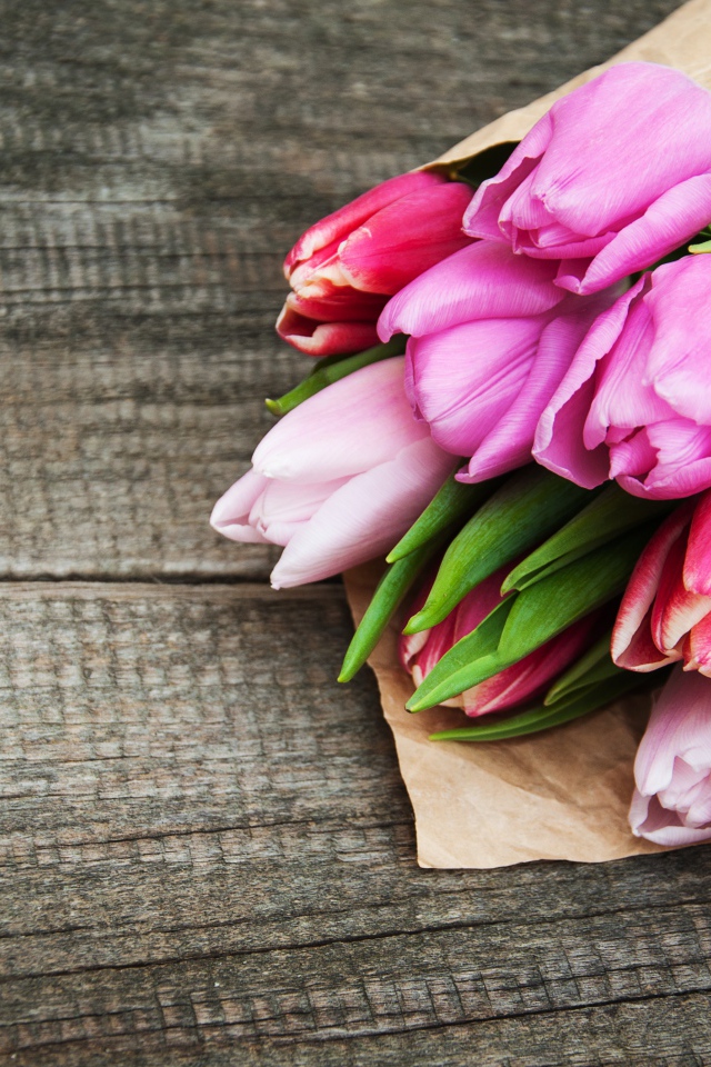 Букет розовых тюльпанов на деревянном столе 