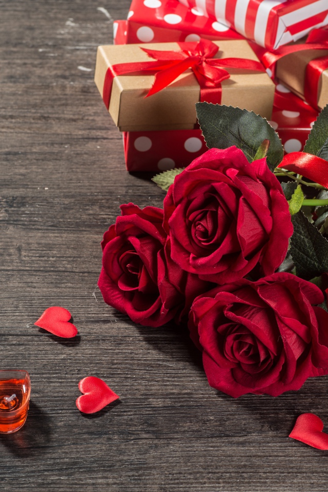 Букет красных роз и подарки на столе 