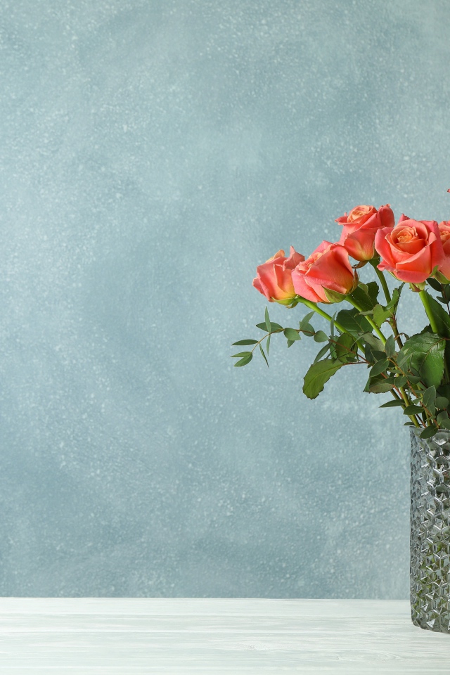 Букет роз в стеклянной вазе на сером фоне