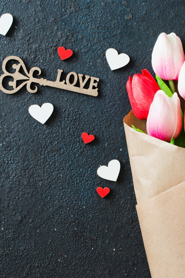 Букет тюльпанов в бумаге на черном фоне с ключом