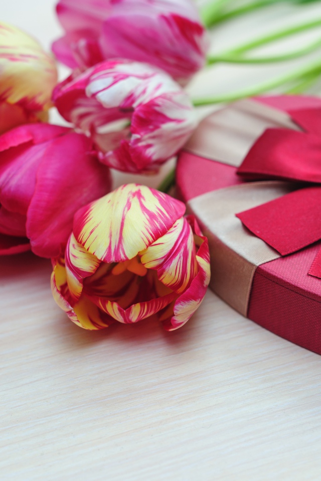 Коробка в форме сердца на столе с букетом тюльпанов