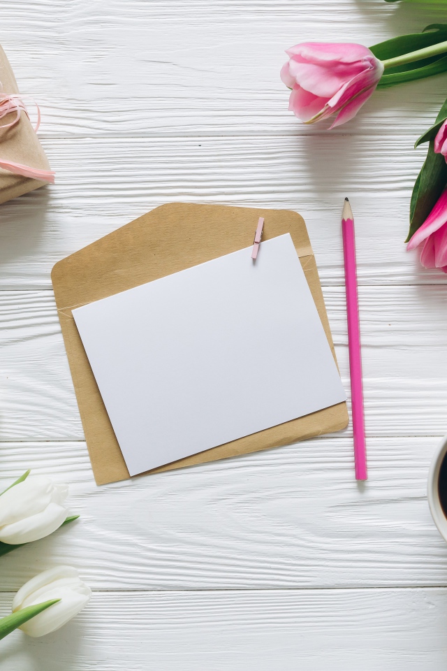 Два букета тюльпанов на столе с подарком, кофе и письмом