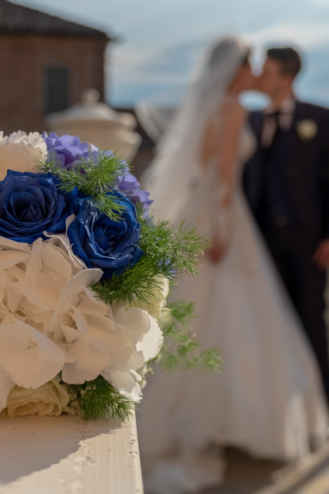 Свадебный букет на фоне новобрачной пары 