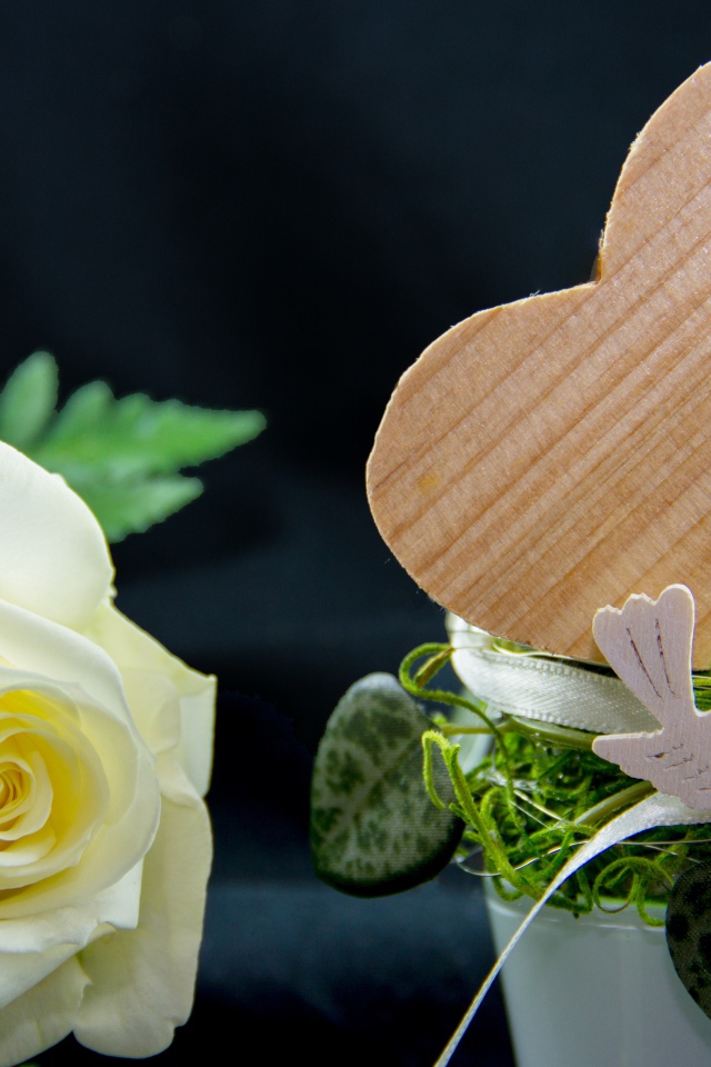 Деревянное сердце и белая роза на столе 