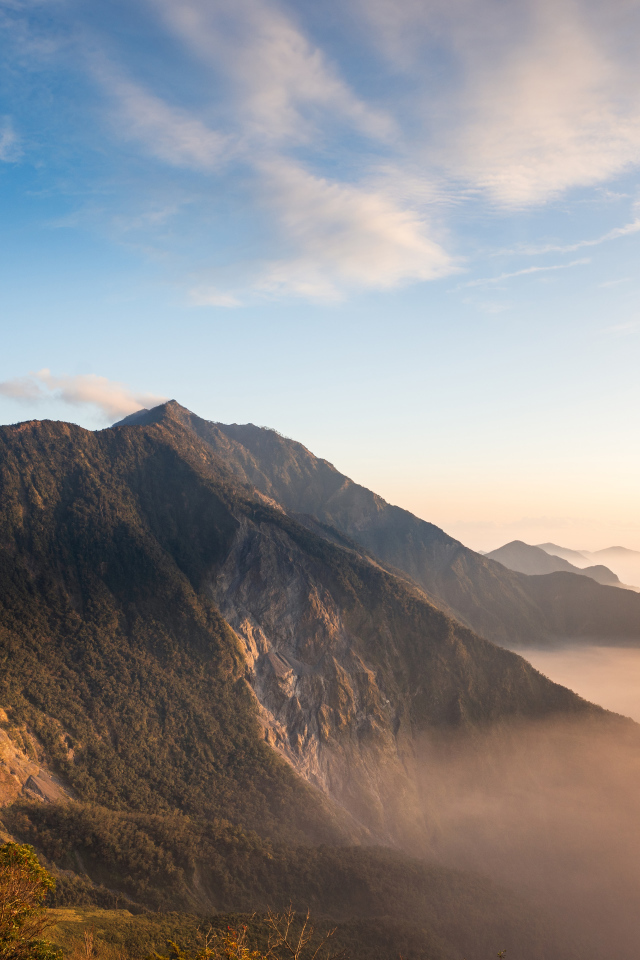 Красивый вид на покрытые туманом горы под голубым небом