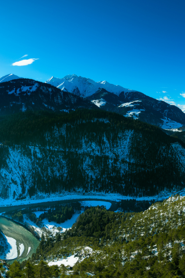 Яркое солнце в голубом небе над заснеженными горами, Швейцария 