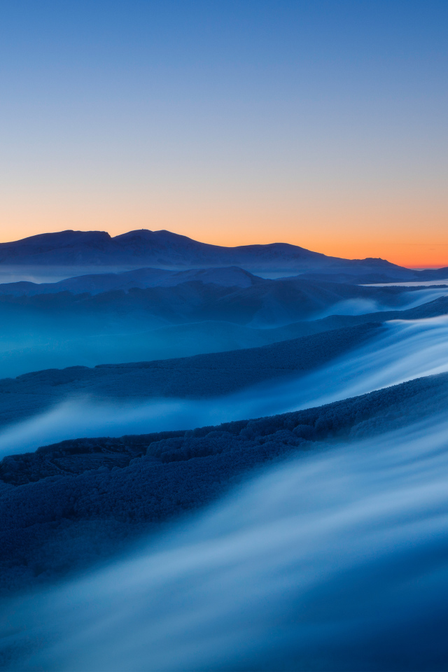 Туман покрывает высокие горы на рассвете 