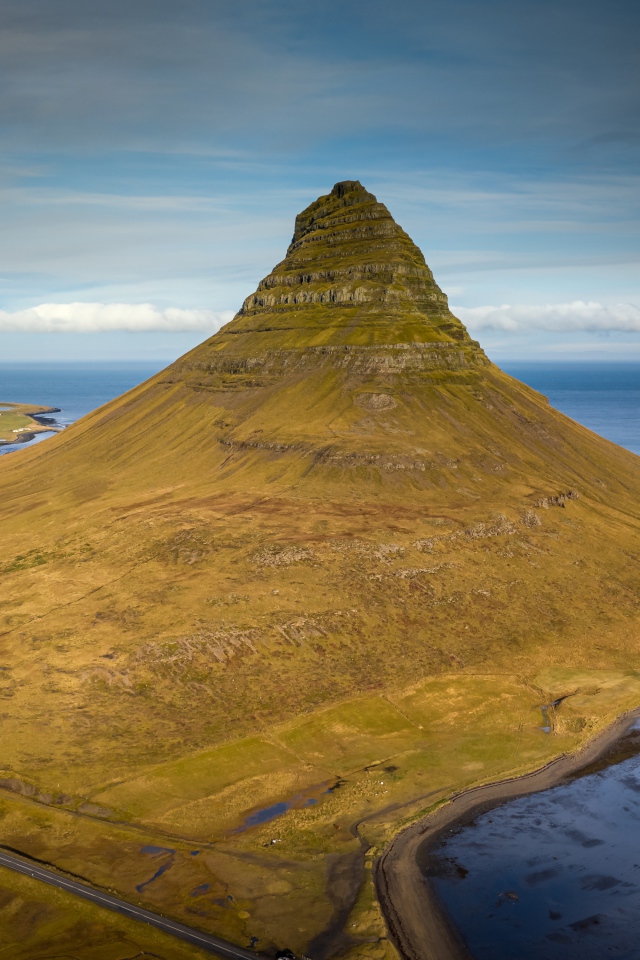 Зеленая гора Киркьюфетль под голубым небом, Исландия