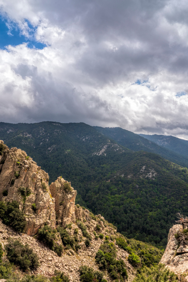 Зеленые вершины гор под белыми облаками 