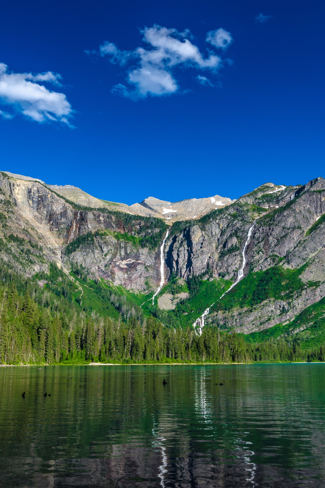 Горы под голубым небом у озера