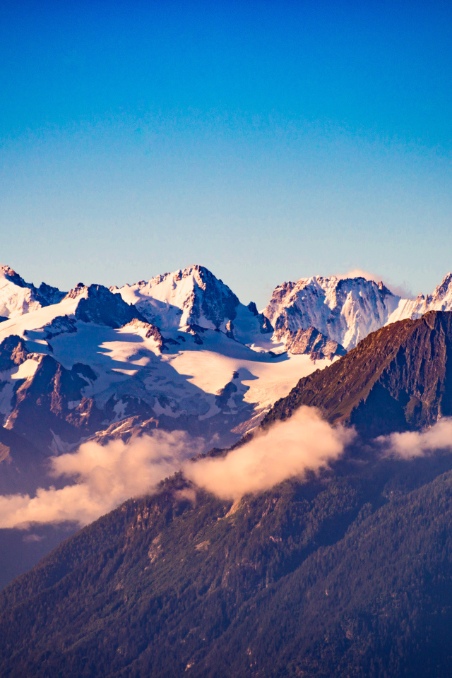 Заснеженные вершины гор под голубым небом