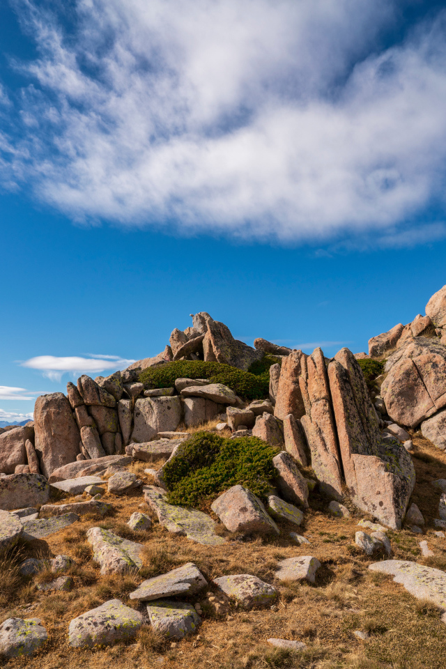 Каменные горы под голубым небом с белыми облаками 