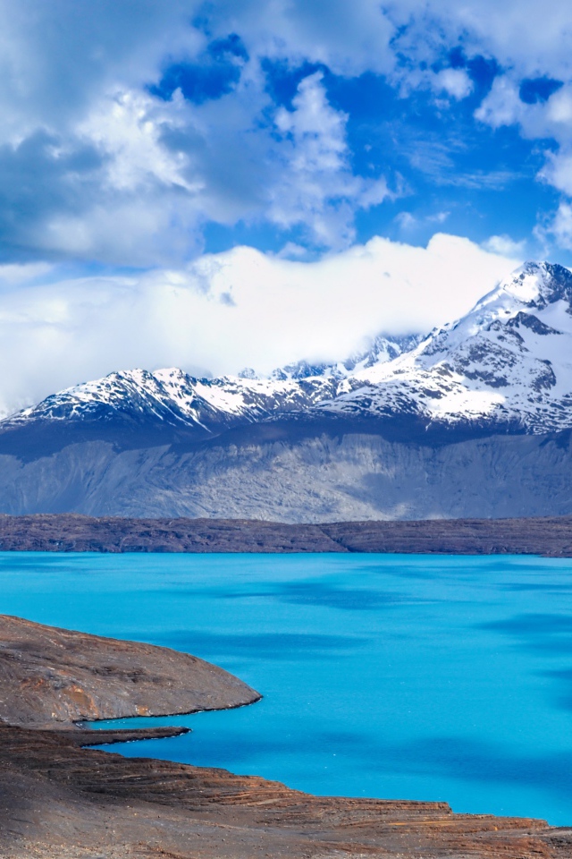 Вид на заснеженную вершину горы у голубого озера 