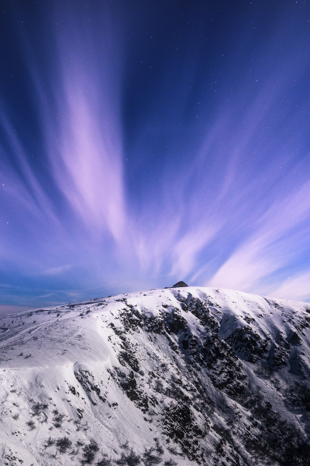 Белые облака в голубом небе над заснеженными горами