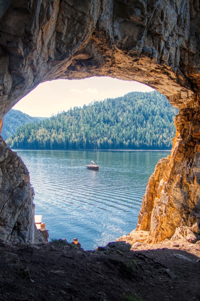 Проход арка в скале ведет к озеру