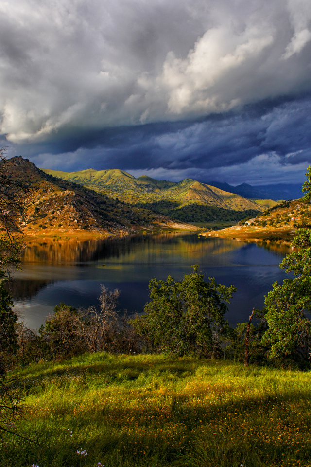 Черные грозовые облака над озером в горах 