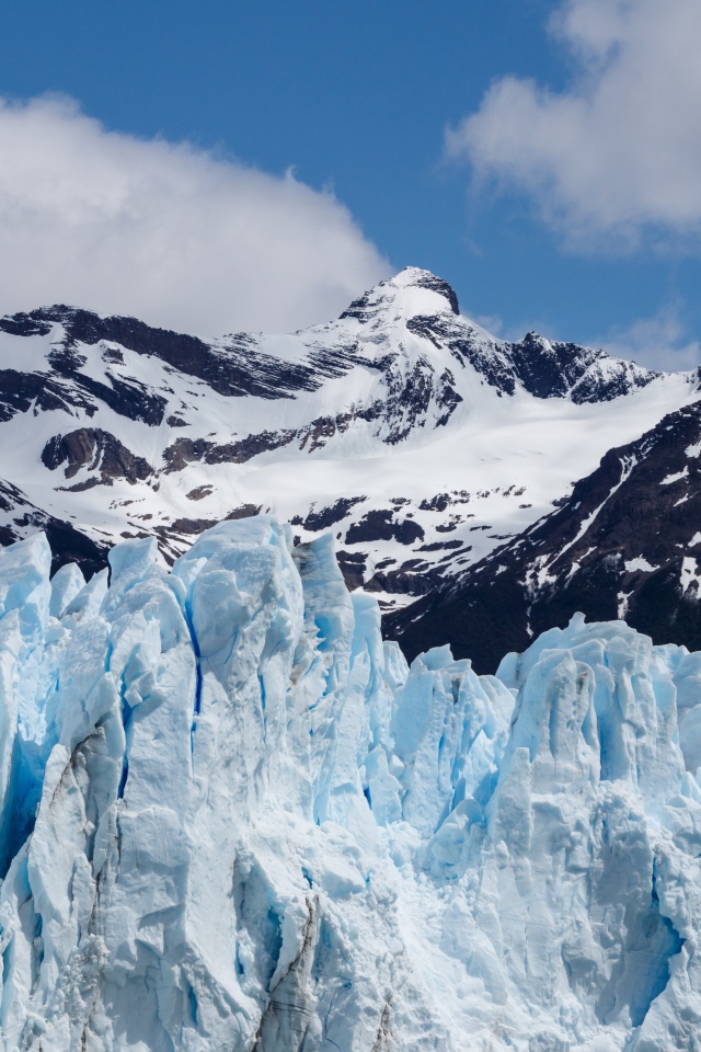 Голубой ледник на фоне заснеженных гор 