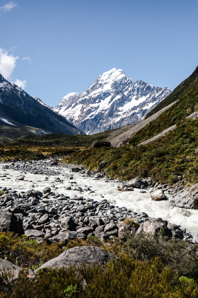 Заледеневшая река на фоне заснеженных гор 