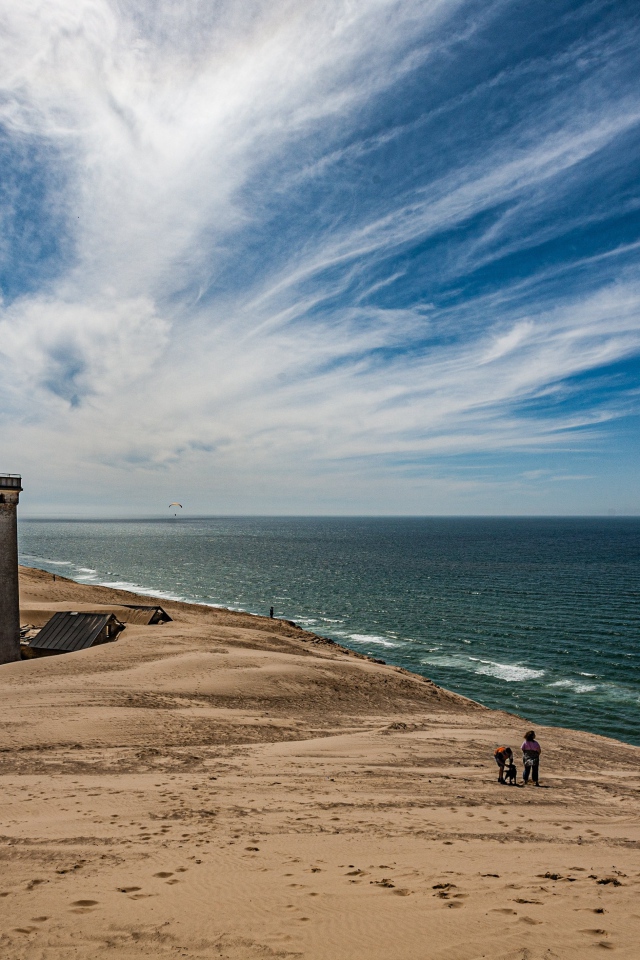 Маяк на песке на берегу моря под голубым небом
