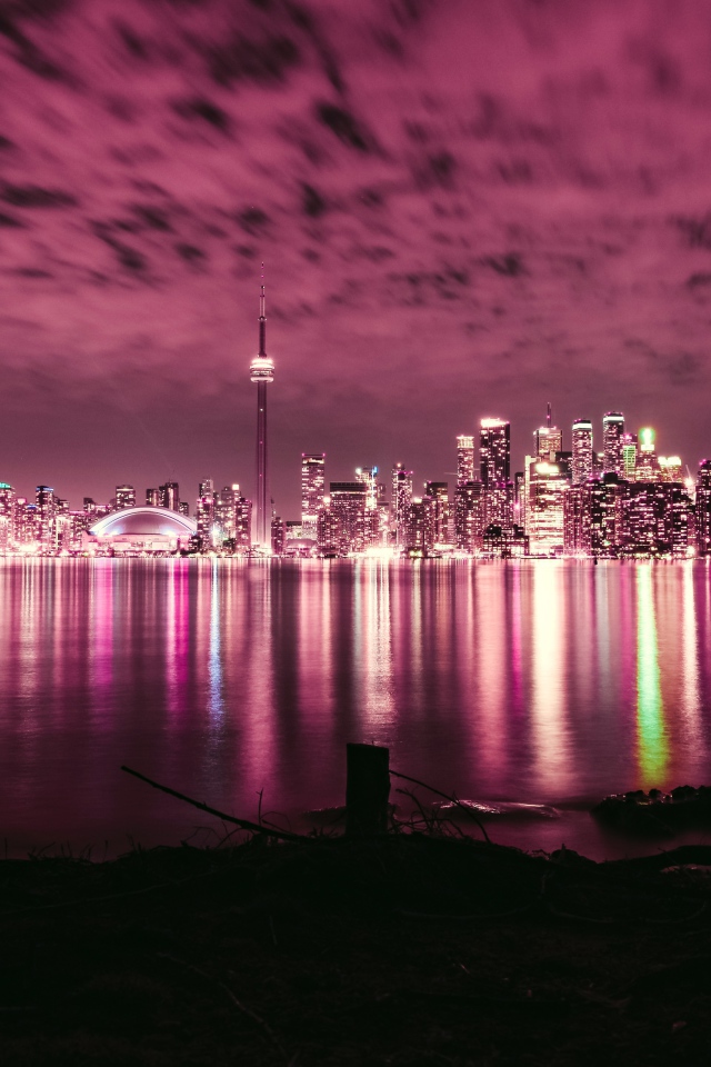 Ночной город под голубым небом отражается в воде 