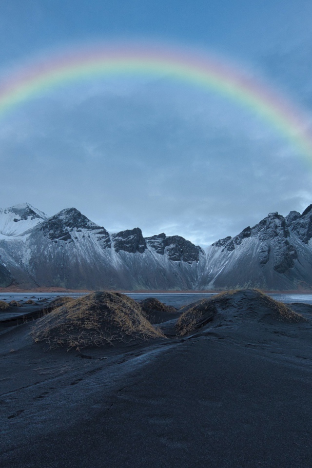 Радуга в небе над высокими горами