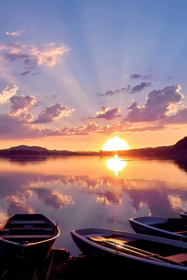 Лодки на берегу озера на закате солнца