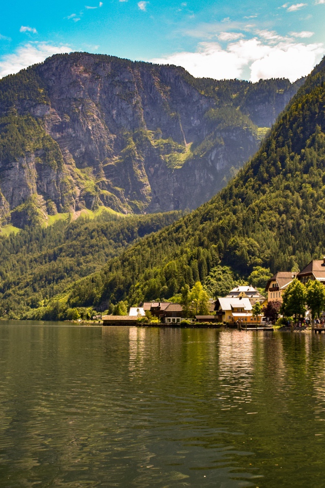 Дома на берегу спокойного горного озера летом