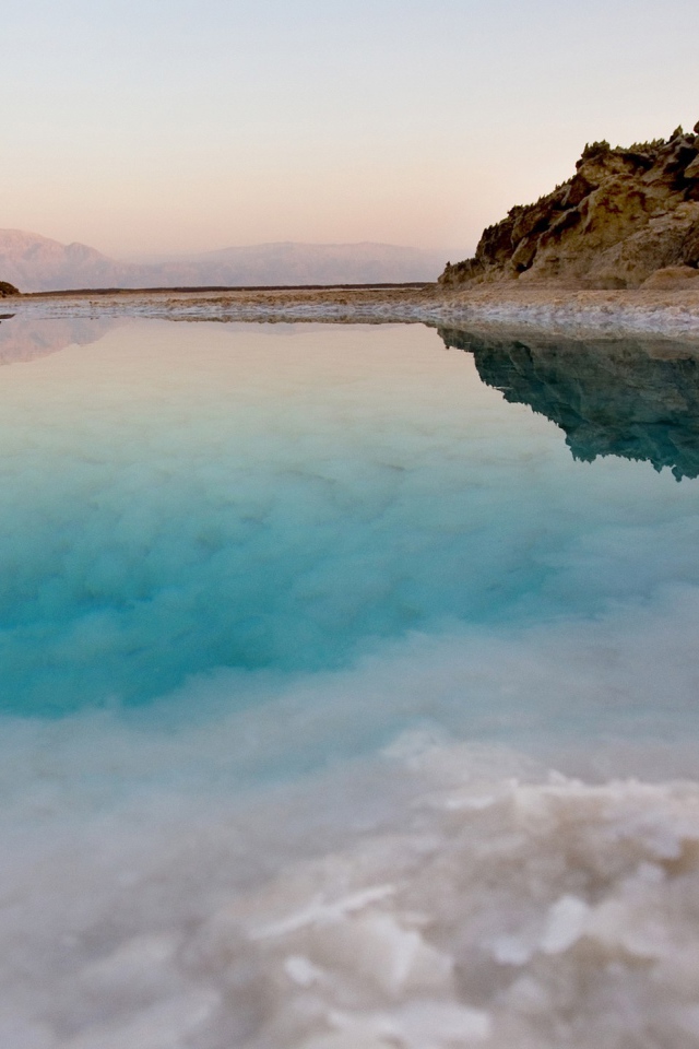 Покрытые льдом берега горного озера с голубой водой