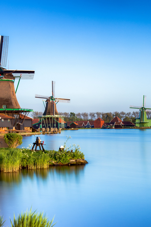 Мельницы  на берегу озера под голубым небом 