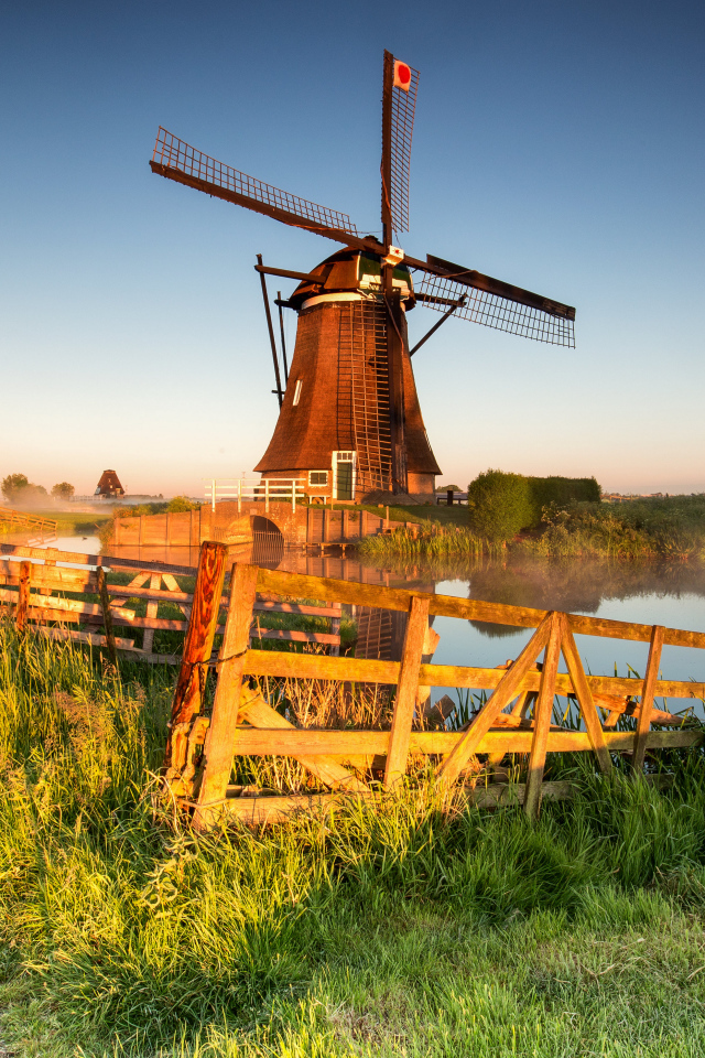 Старая мельница на берегу озера на ферме 