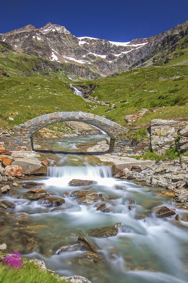 Маленький каменный мост через горную реку 