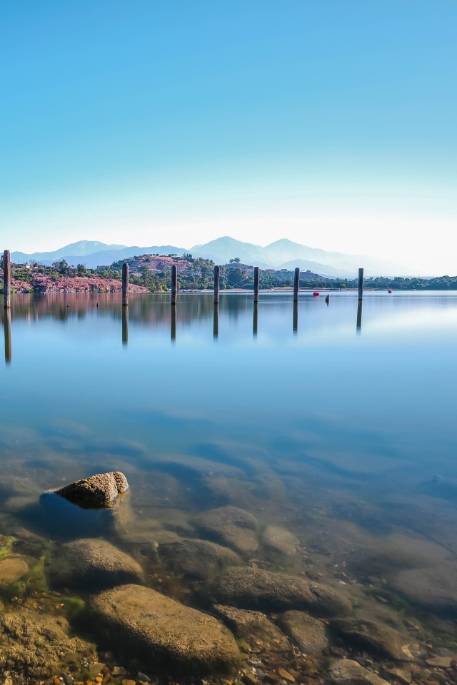 Камни в озере на фоне голубого неба