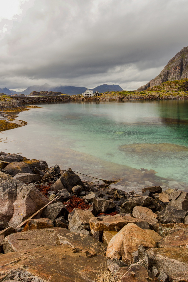 Камни на берегу горного озера под грозовым небом