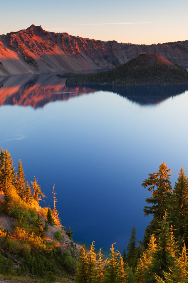 Небо отражается в горном озере в лучах солнца