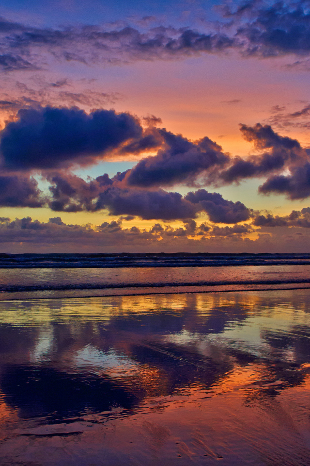 Черные тучи отражаются в морской воде на закате