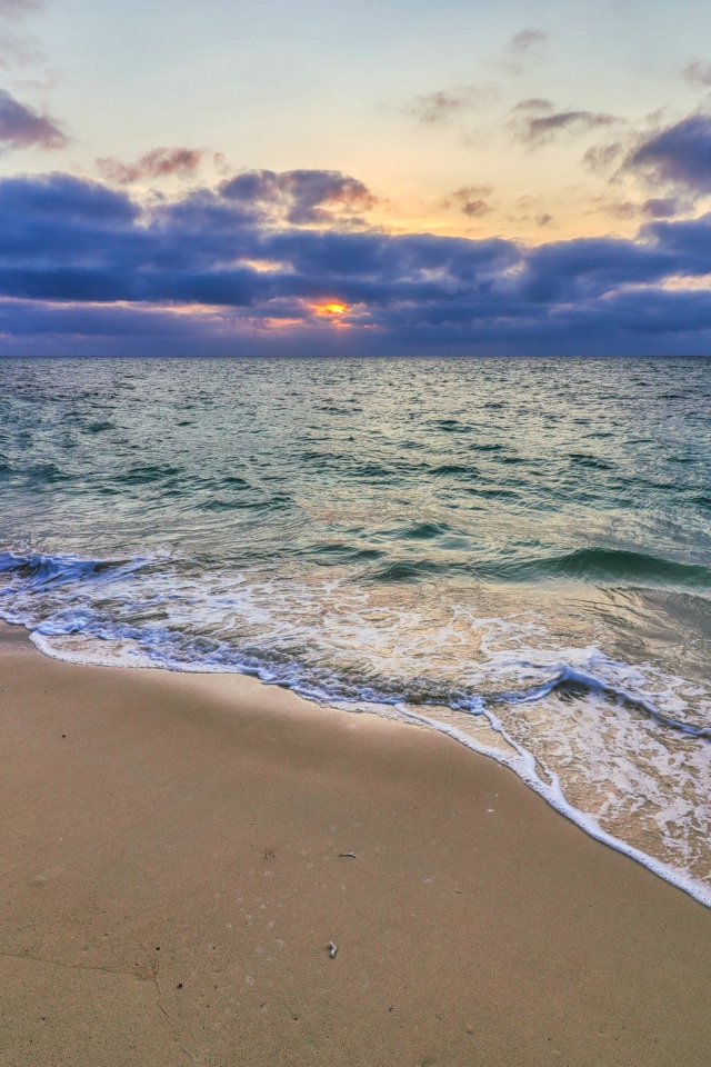 Голубая морская вода на песке на закате солнца
