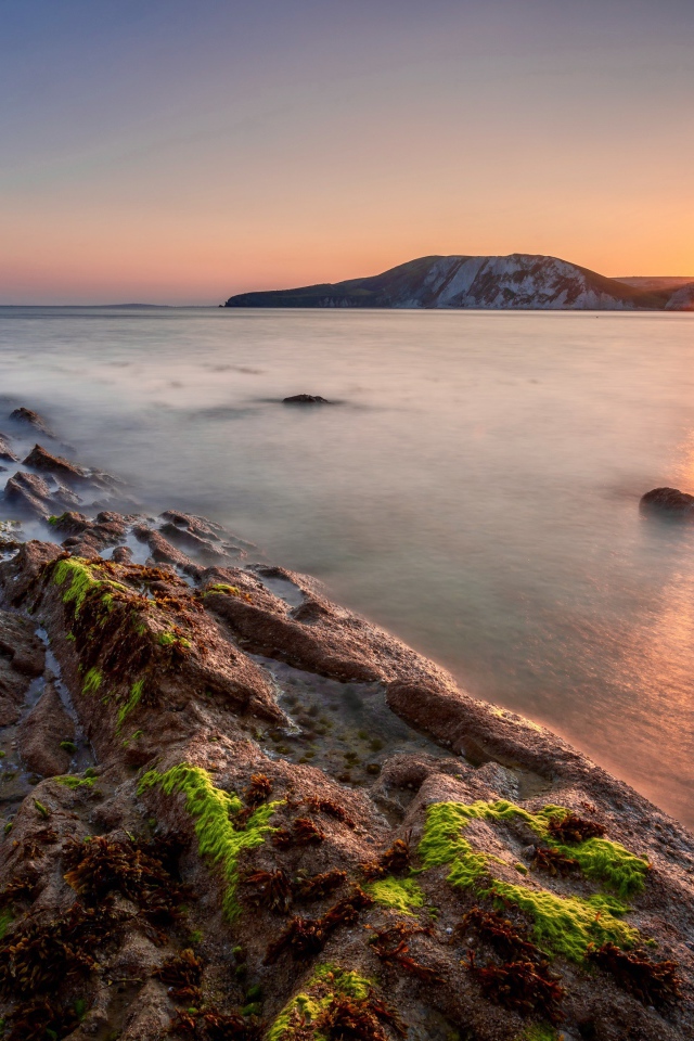 Спокойная вода в море с подводными камнями на закате 