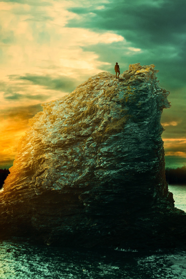 Скала в море на закате солнца