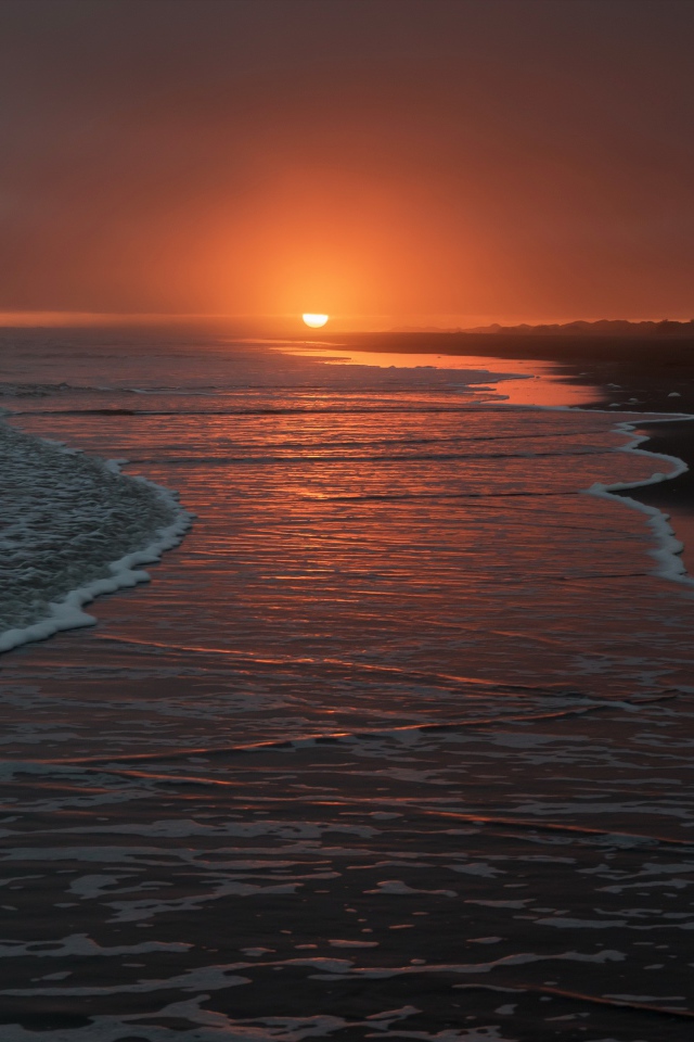 Тихие волны на берегу моря на закате