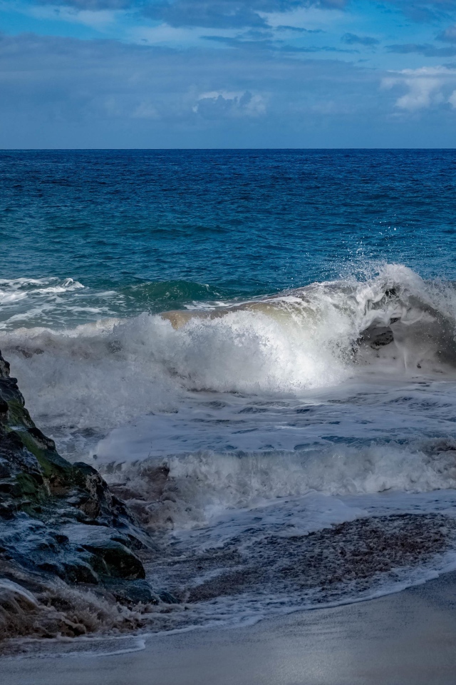 Бушующие белые волны в море у скал 