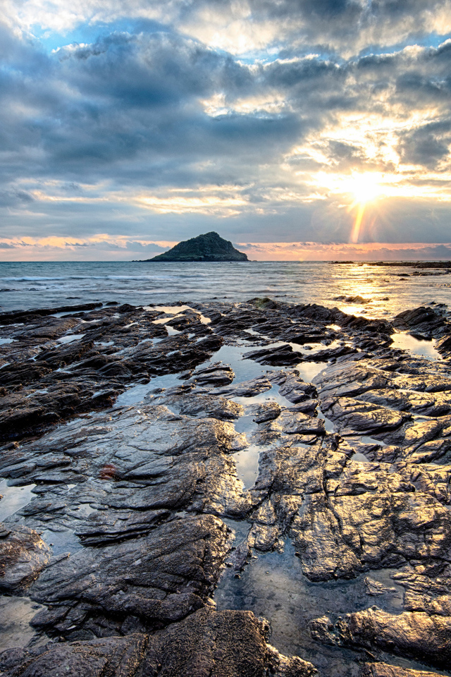 Каменный берег океана в лучах солнца