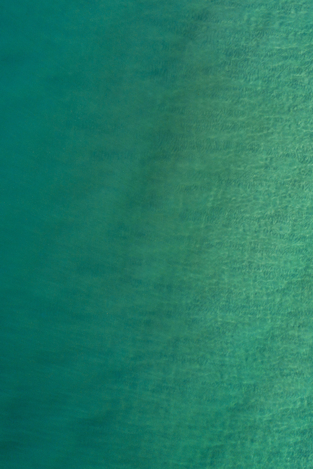 Вид сверху на спокойную голубую гладь океана