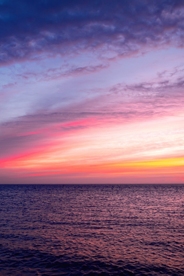 Красивый розовый закат в небе над тихим морем