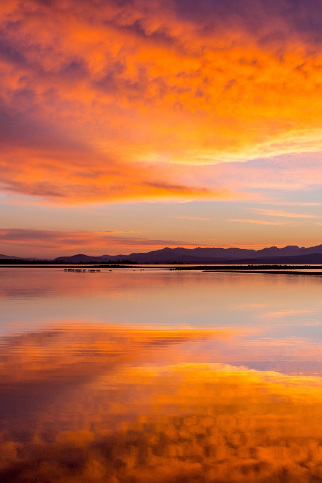 Красивое небо на закате отражается в спокойной воде озера