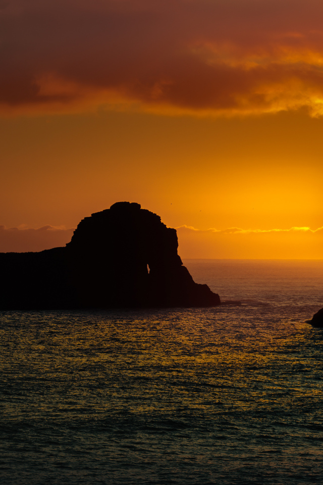 Скалы в море на закате солнца  