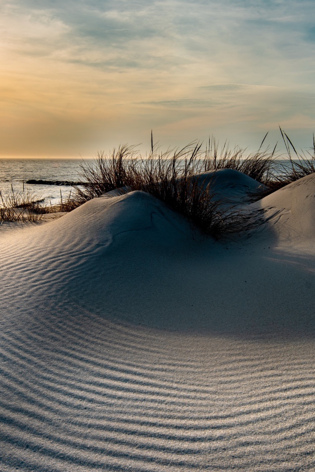 Горячий песок на берегу моря на закате 